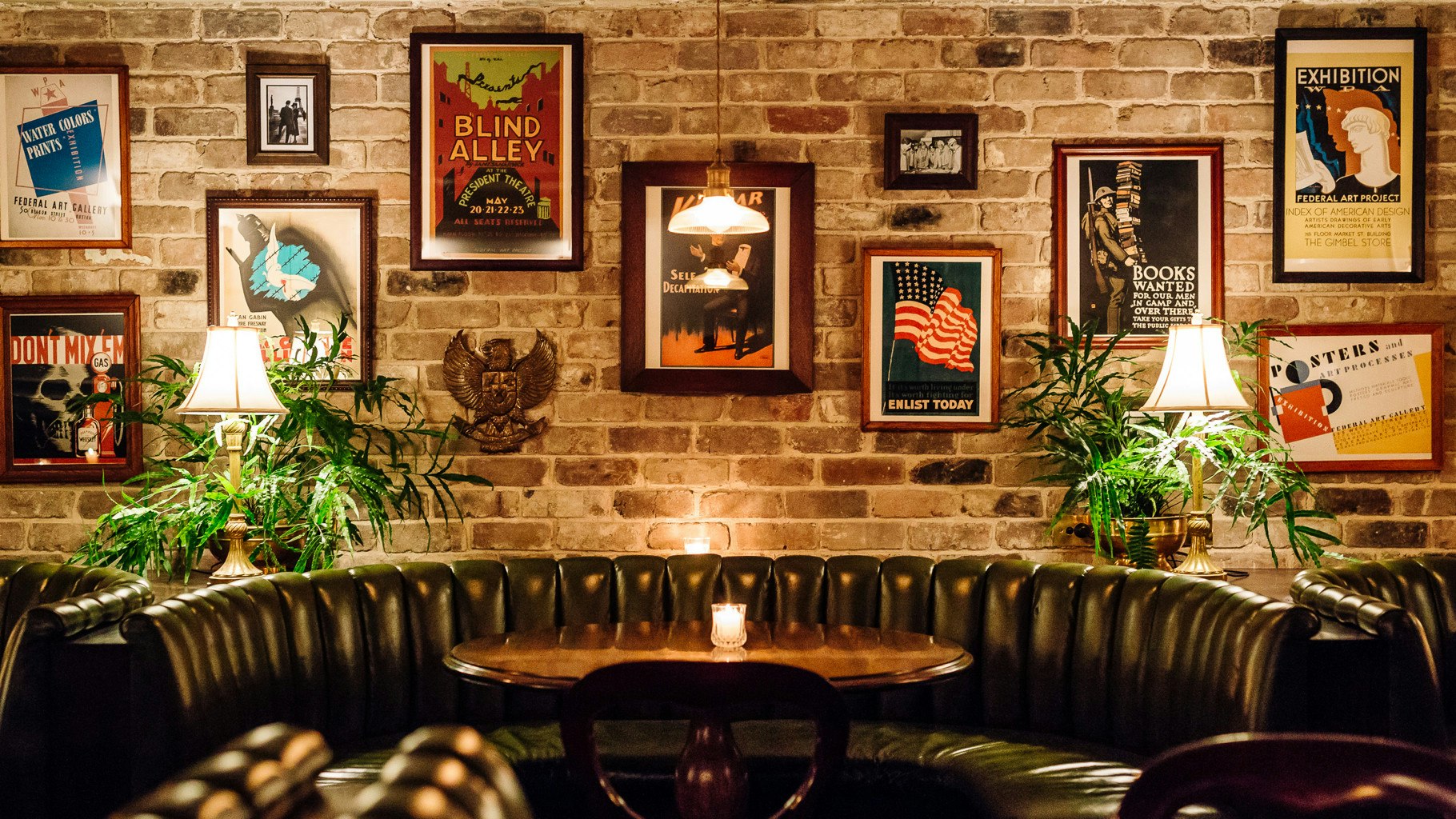 Brickwork wall, with vintage posters hanging.